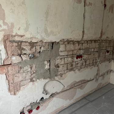 Sanierungsarbeiten an Innenwand als Vorbereitung für neuen Wandaufbau